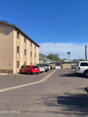 a view of building with cars parked on road