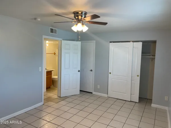 a view of an empty room and chandelier fan
