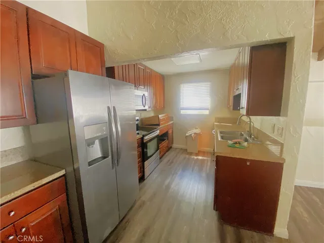 a kitchen with a refrigerator sink and wooden cabinets