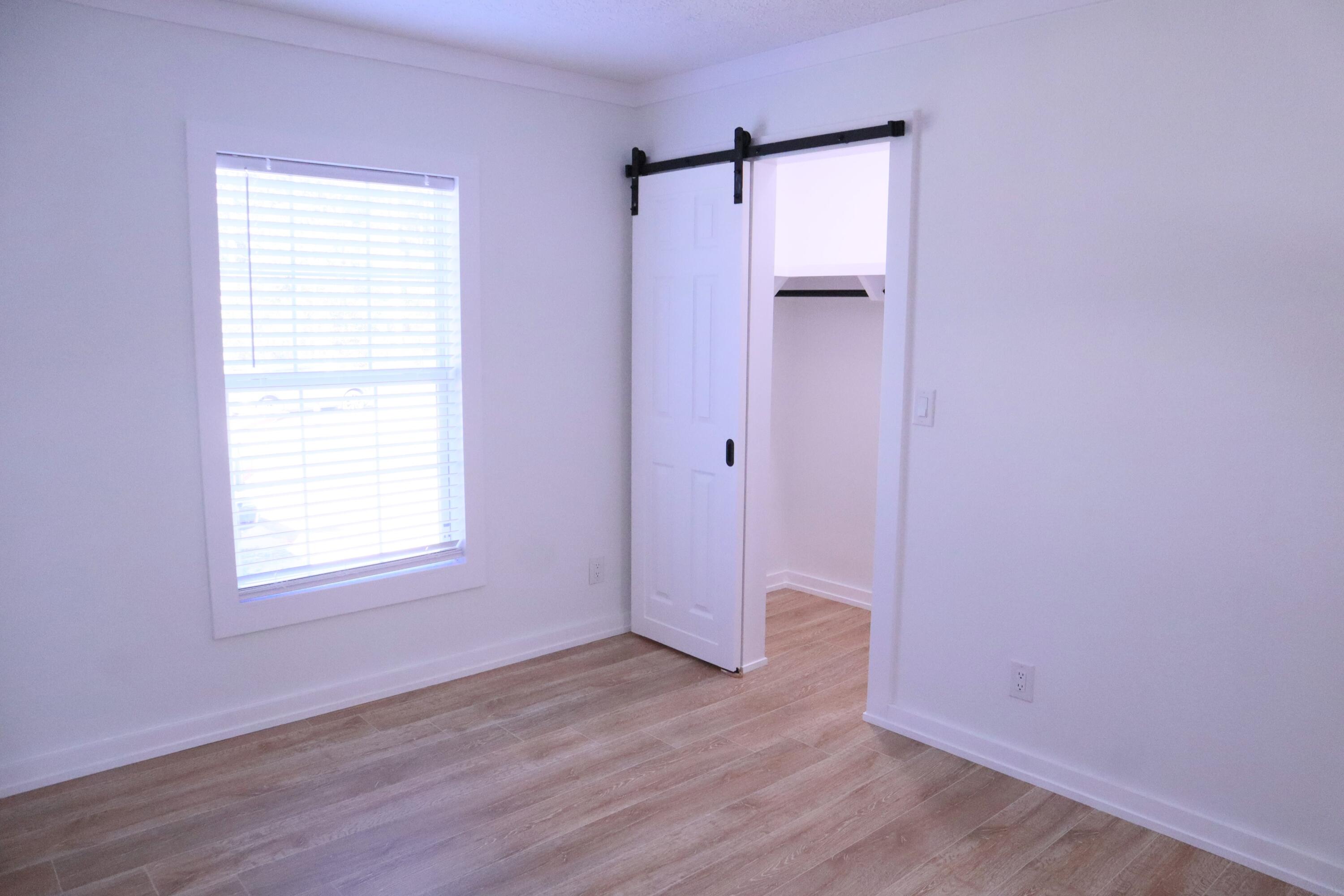 4608 Falcon Way Crestview, FL 32539 - Photo 34 of 42 an empty room with wooden floor and a window
