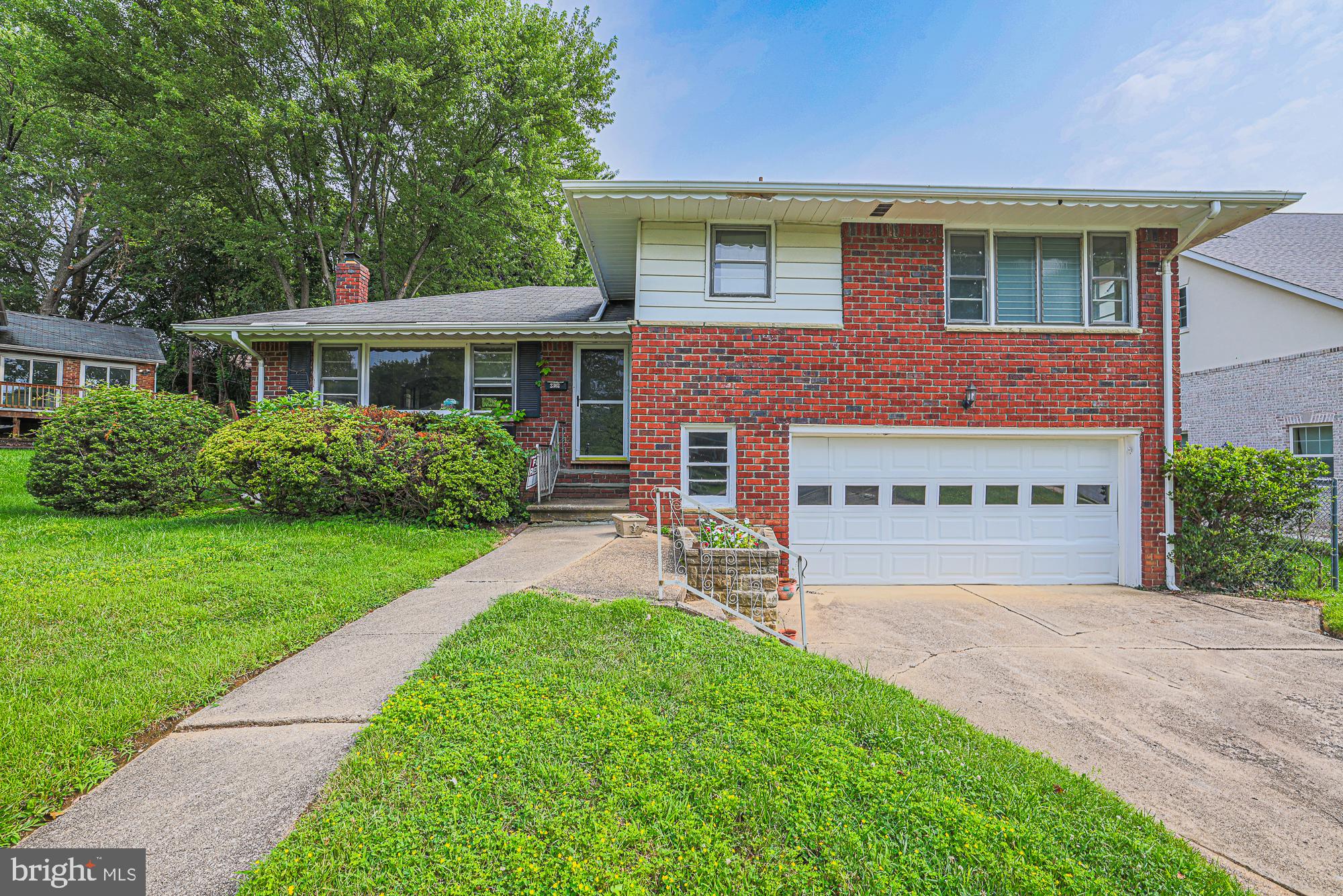 2302 Farringdon Road Baltimore, MD 21209 - Photo 2 of 19 Charming brick home with lush greenery.