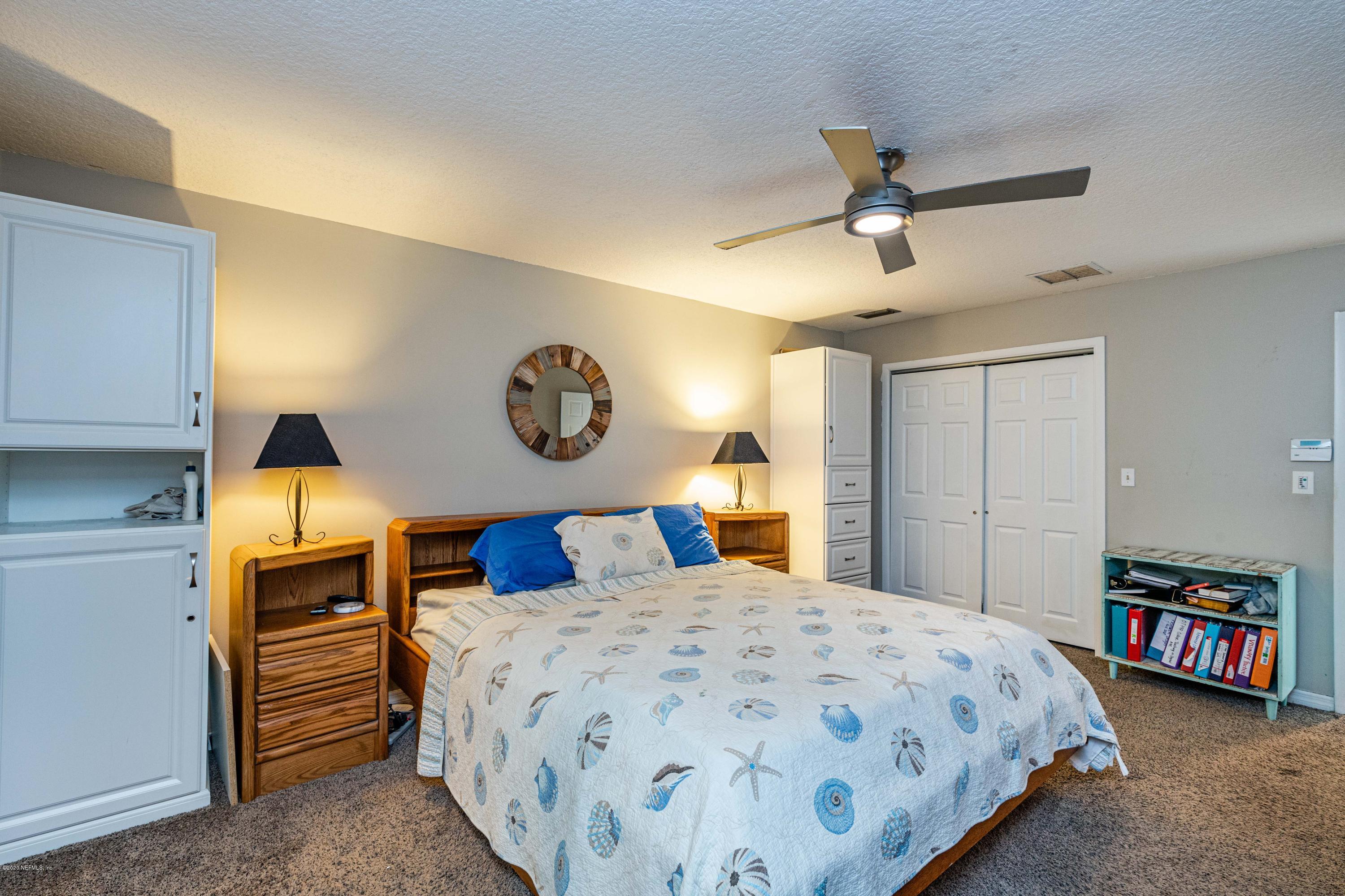 56 Solana Road Ponte Vedra Beach, FL 32082 - Photo 24 of 47 a bedroom with a large bed and a chandelier