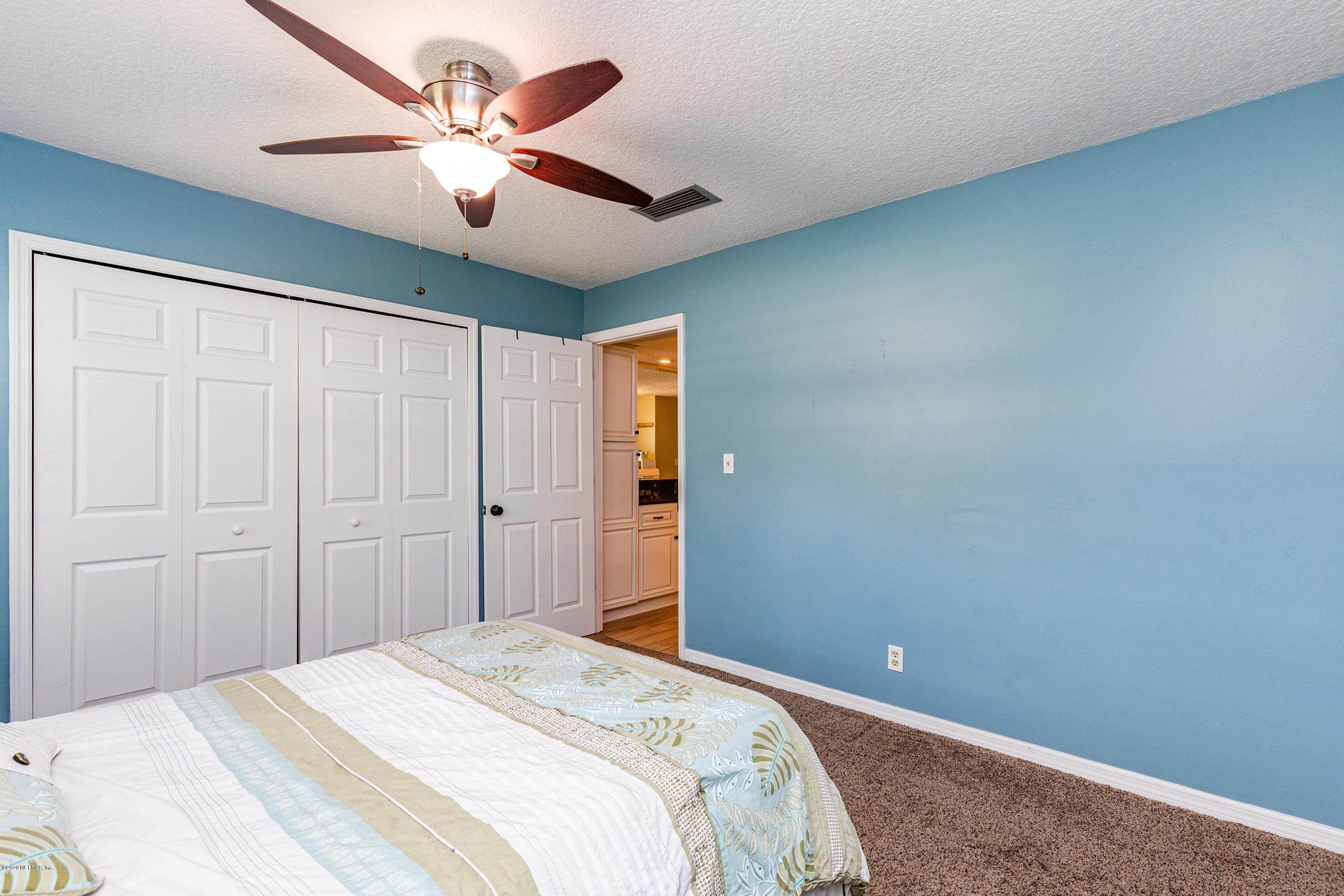 56 Solana Road Ponte Vedra Beach, FL 32082 - Photo 33 of 47 a bedroom with a large bed chandelier and a window