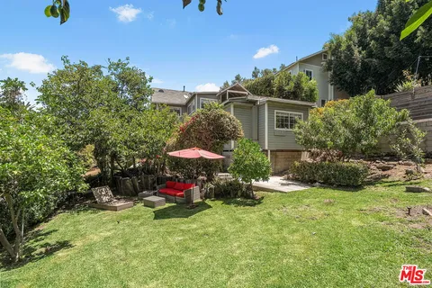 a view of a backyard with table and chairs and potted plants