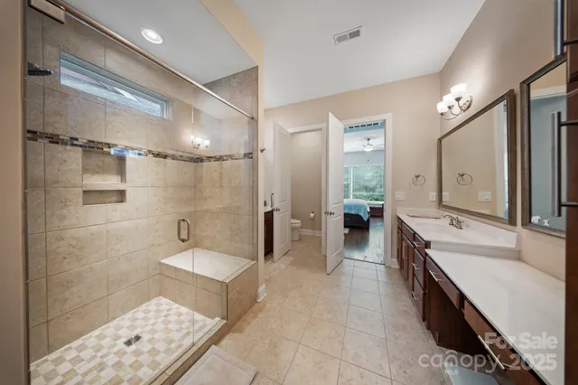 a large bathroom with a double vanity sink a large mirror and shower