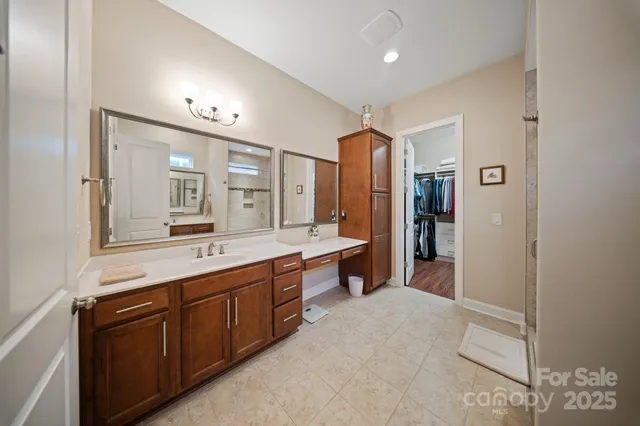a large bathroom with a double vanity sink a large mirror and a bathtub