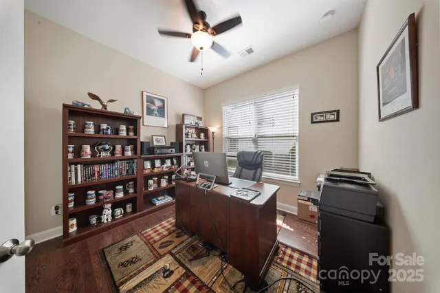 a living room with furniture a rug and a book shelf