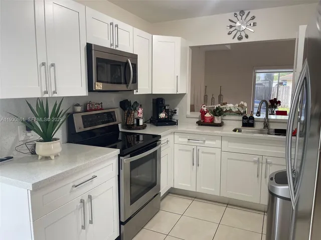a kitchen with white cabinets stainless steel appliances and sink