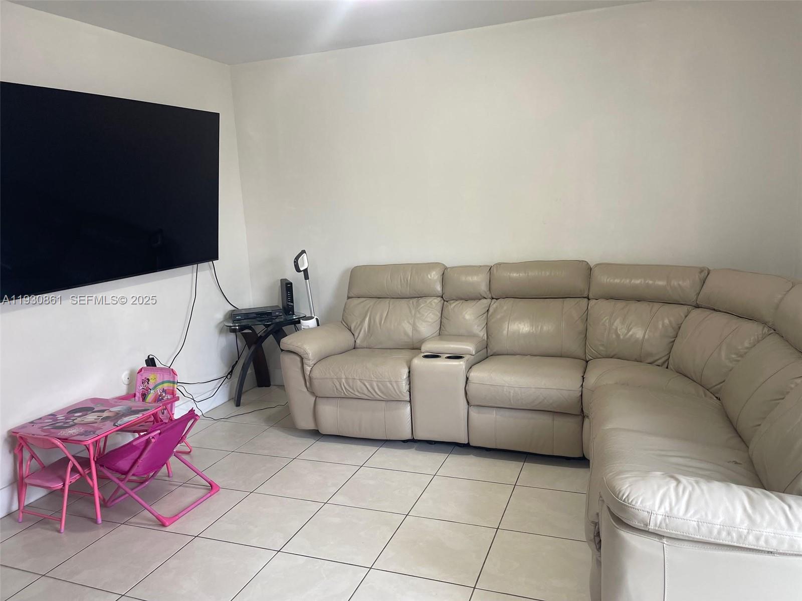 20420 Southwest 124th Place, Unit 20420 Miami, FL 33177 - Photo 13 of 16 a living room with furniture and a flat screen tv