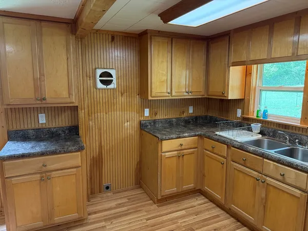 a kitchen with granite countertop cabinets stainless steel appliances a sink and a window