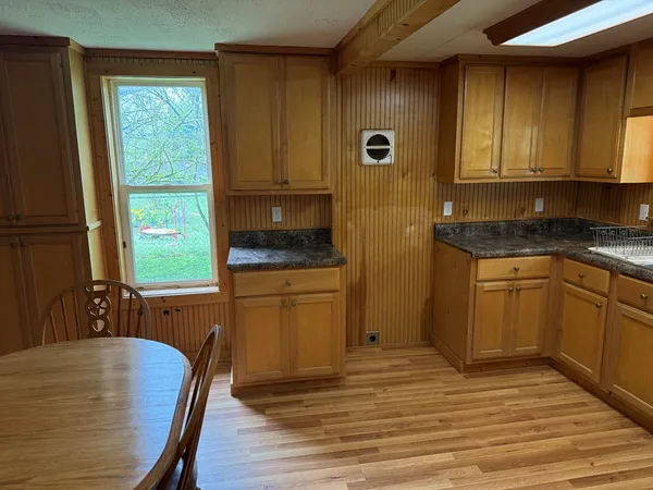 a kitchen with stainless steel appliances granite countertop a stove a sink dishwasher and a refrigerator with wooden floor