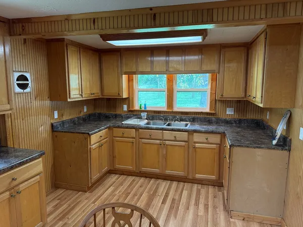 a kitchen with granite countertop cabinets stainless steel appliances a sink and a window