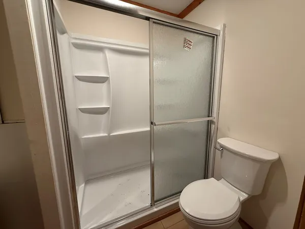 a white toilet sitting next to a shower