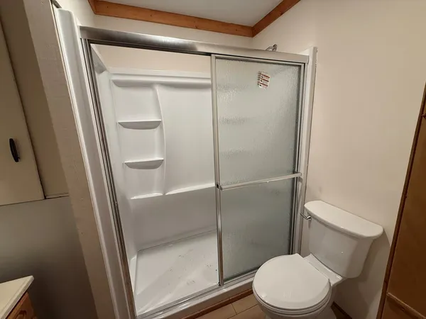 a white toilet sitting next to a shower