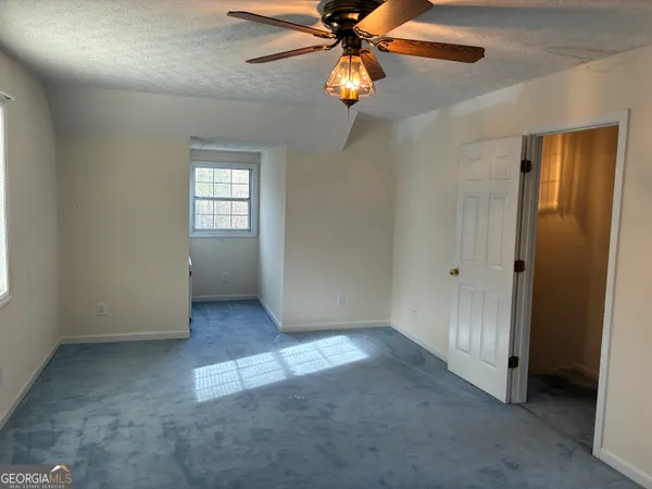 en view of a room with a chandelier fan and windows