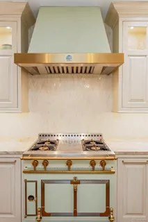 a stove top oven sitting inside of a kitchen