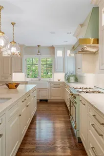 a large kitchen with a large window a sink and a stove