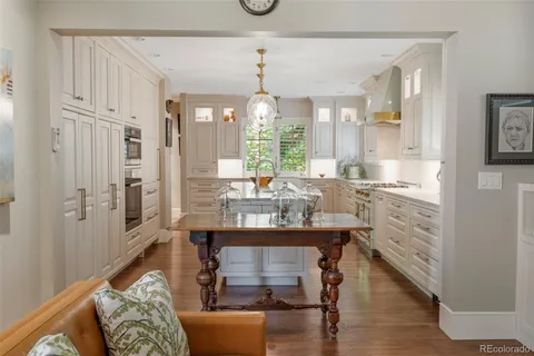 a dining room with furniture a chandelier and wooden floor