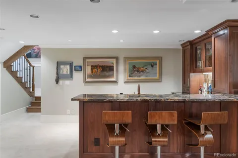 a kitchen with granite countertop a sink and chairs