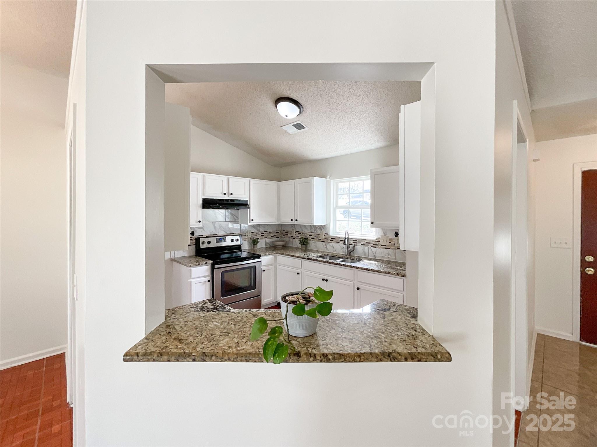 5610 Stone Bluff Court Charlotte, NC 28214 - Photo 14 of 41 a kitchen with a stove a sink and a refrigerator