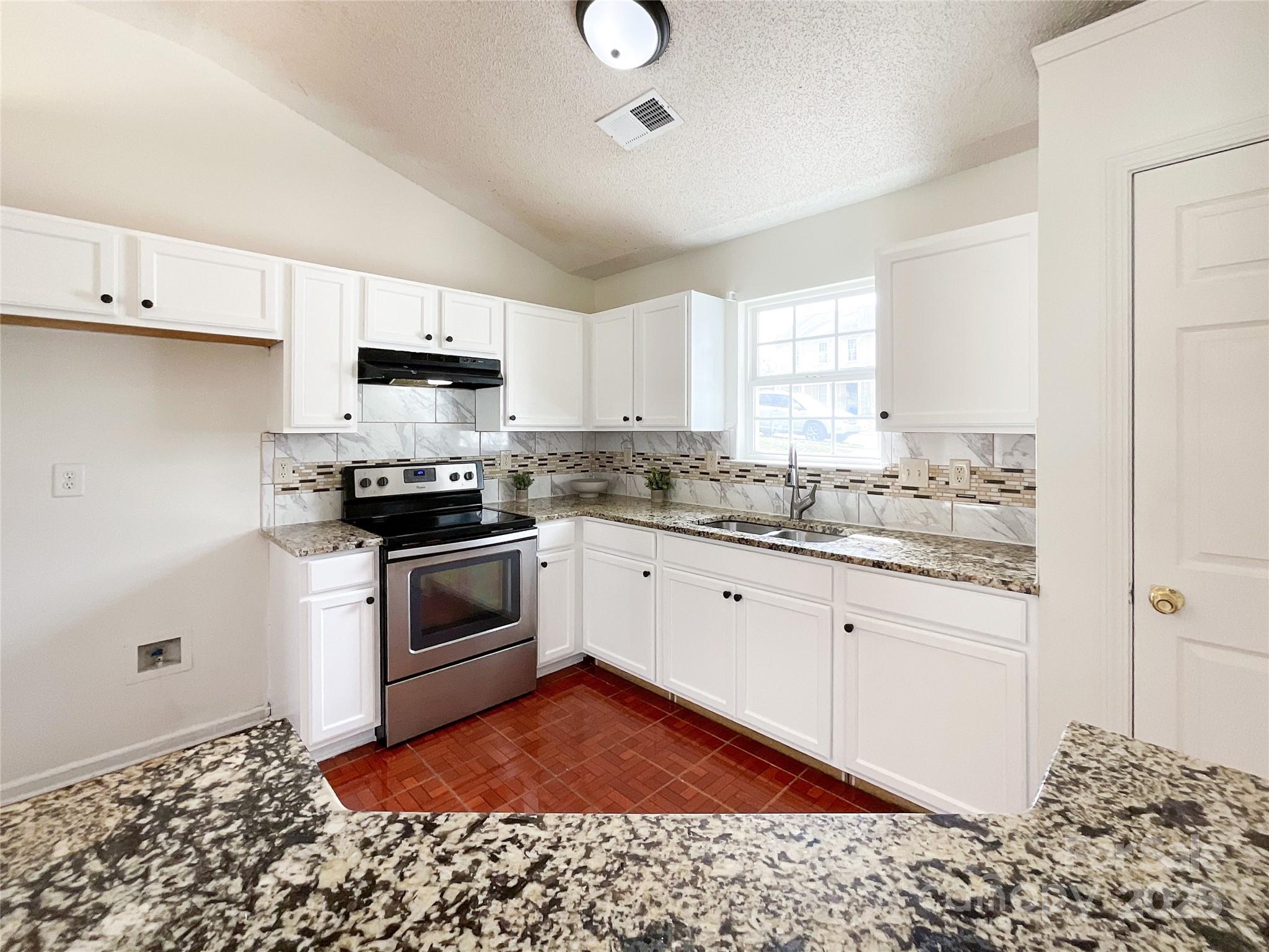 5610 Stone Bluff Court Charlotte, NC 28214 - Photo 15 of 41 a kitchen with a sink stove and white cabinets