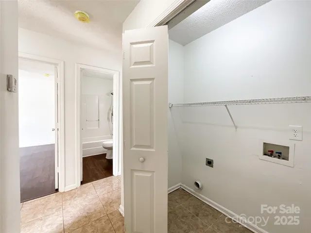an empty room with wooden floor cabinet and windows