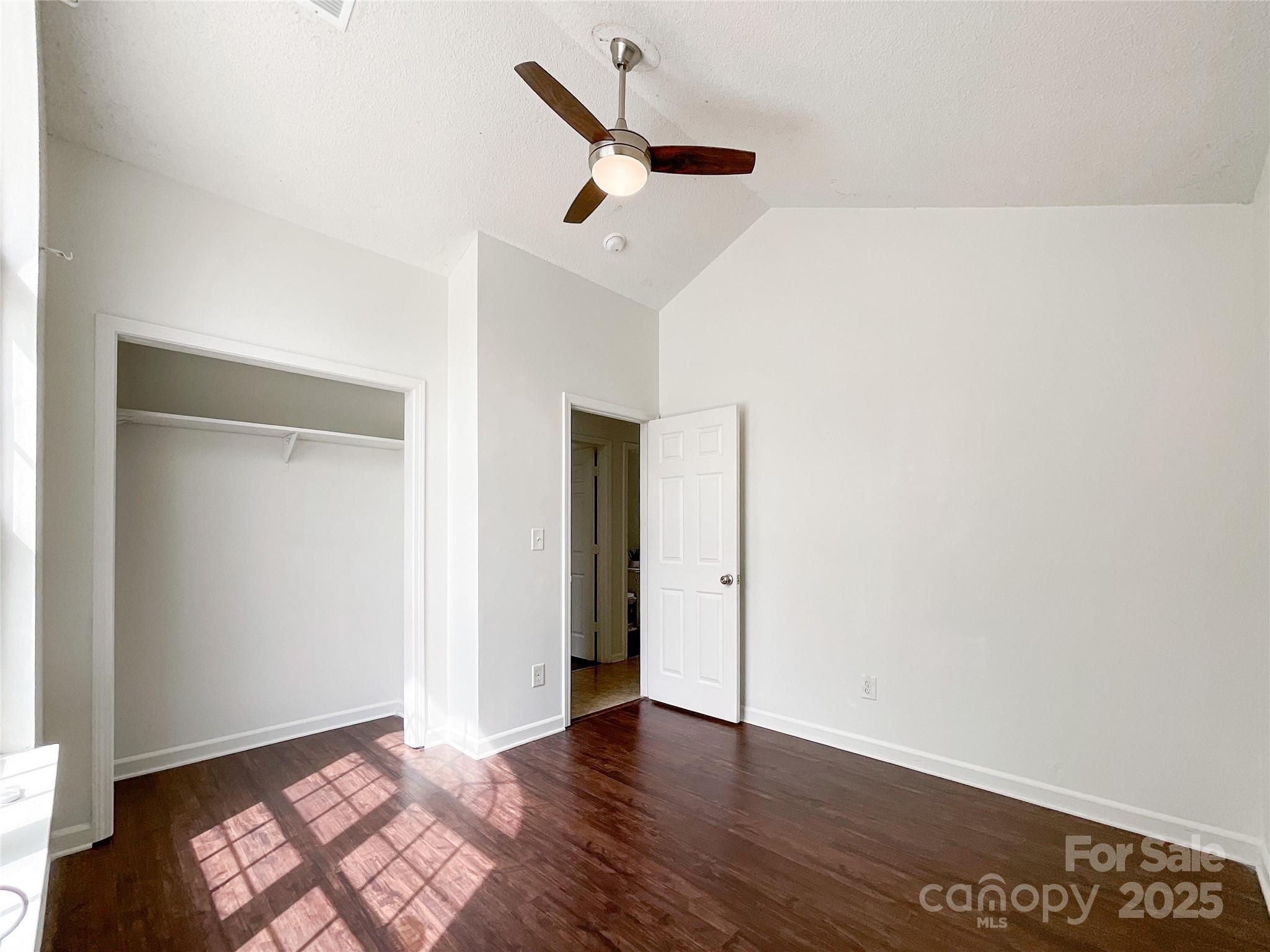 5610 Stone Bluff Court Charlotte, NC 28214 - Photo 19 of 41 an empty room with wooden floor ceiling fan and window