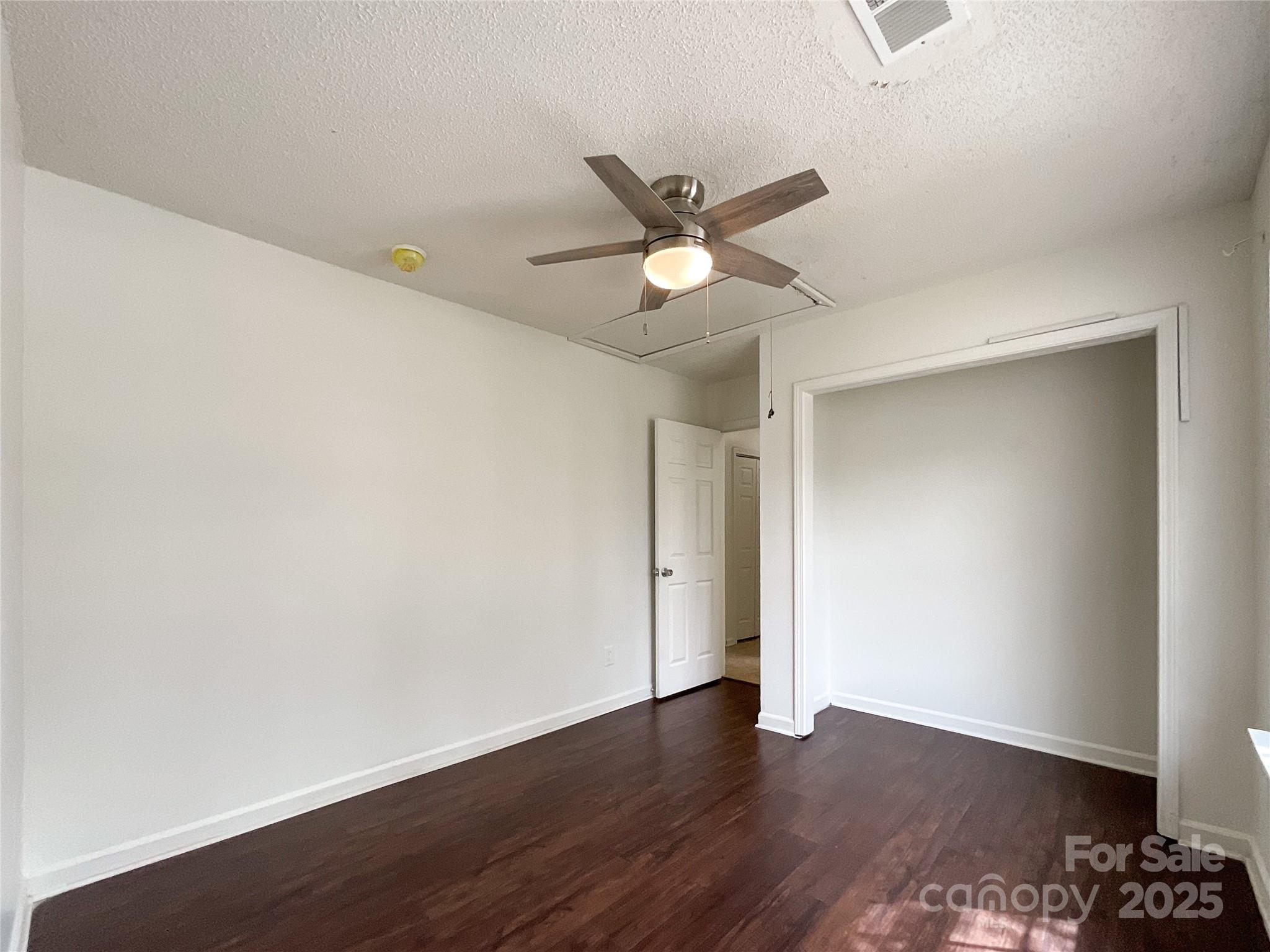 5610 Stone Bluff Court Charlotte, NC 28214 - Photo 21 of 41 an empty room with wooden floor and a ceiling fan