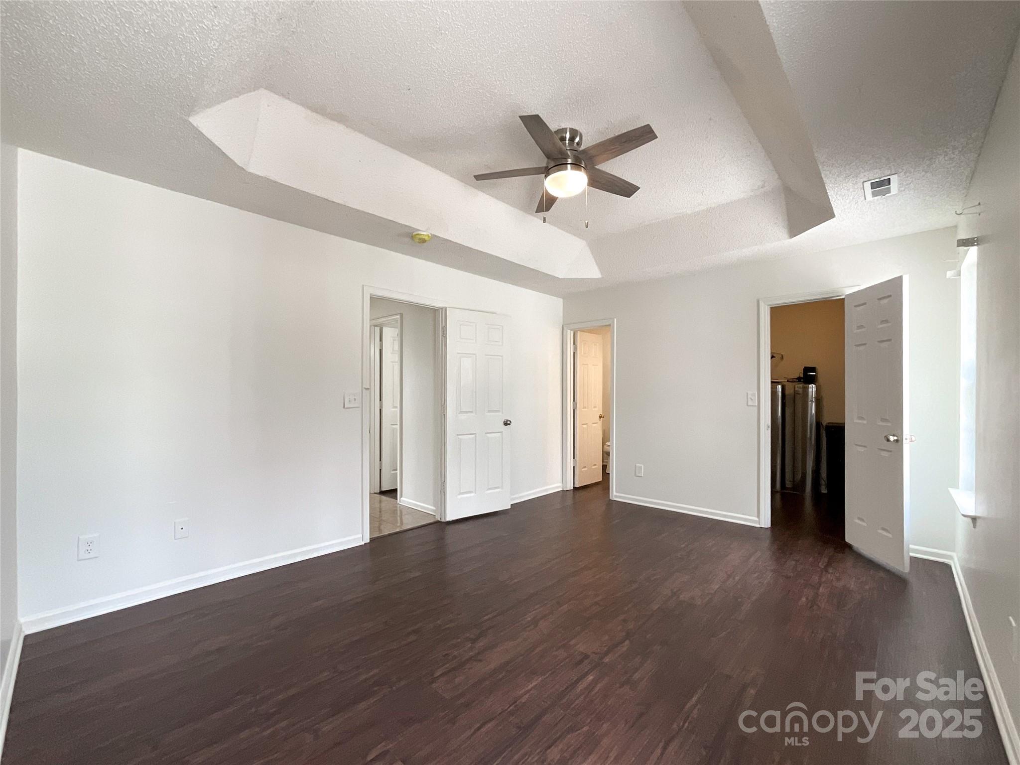 5610 Stone Bluff Court Charlotte, NC 28214 - Photo 26 of 41 a view of an empty room with wooden floor and a ceiling fan