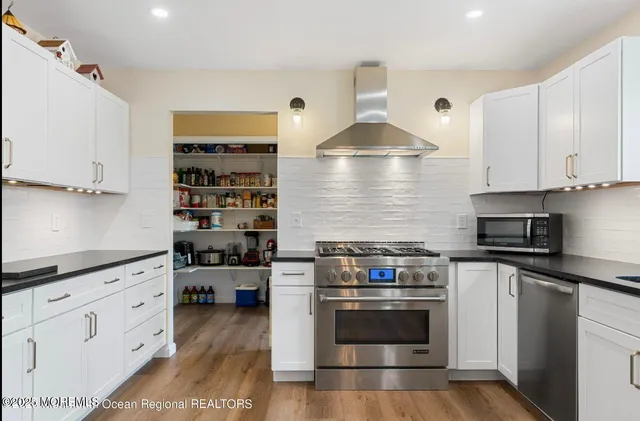 a kitchen with granite countertop a stove a sink and a microwave
