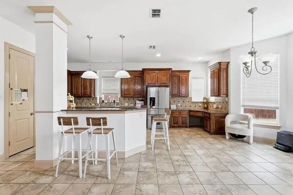 a kitchen with cabinets and chairs