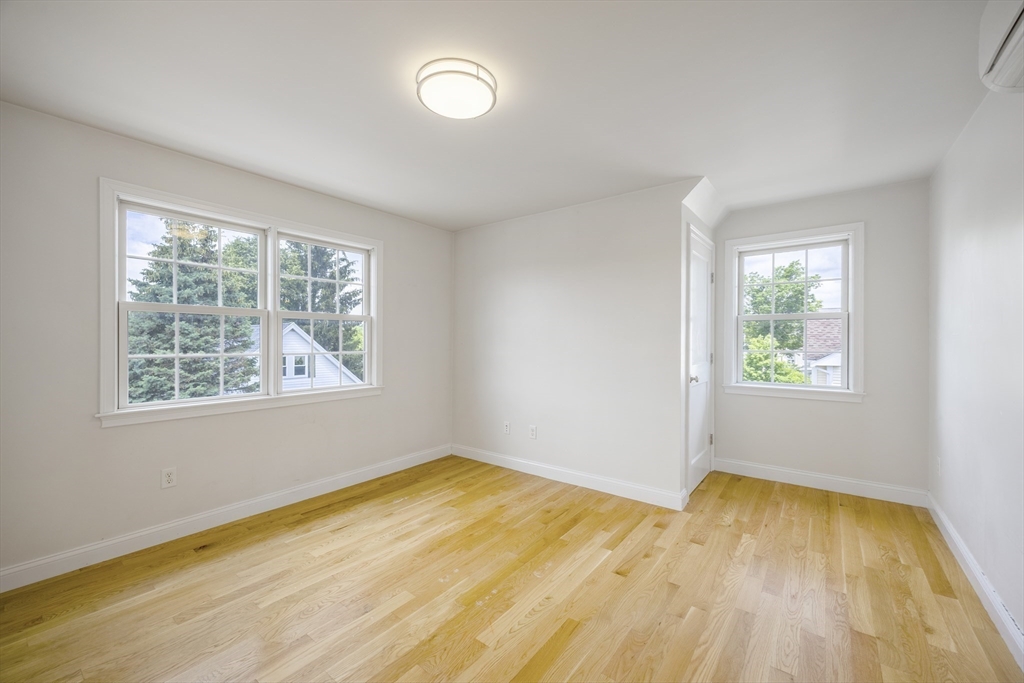 48 Spruce Street, Unit 1 Winchester, MA 01890 - Photo 20 of 29 a view of empty room with window and wooden floor