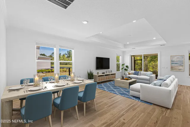 a living room with furniture a flat screen tv and a large window