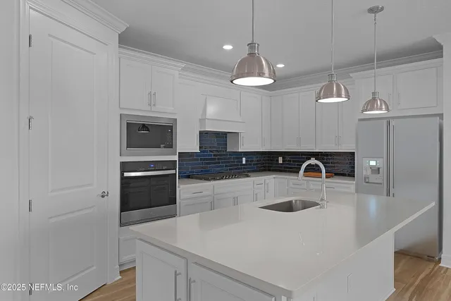 a kitchen with kitchen island a sink stainless steel appliances and cabinets