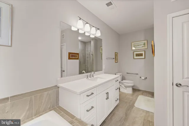 a spacious bathroom with a double vanity sink mirror and toilet