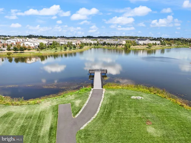 a living room with furniture large window and wooden floor