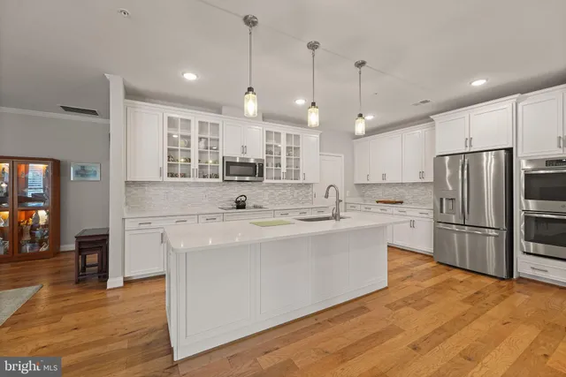 a large kitchen with kitchen island a sink stainless steel appliances and cabinets