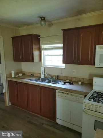a kitchen with granite countertop wood cabinets and white appliances