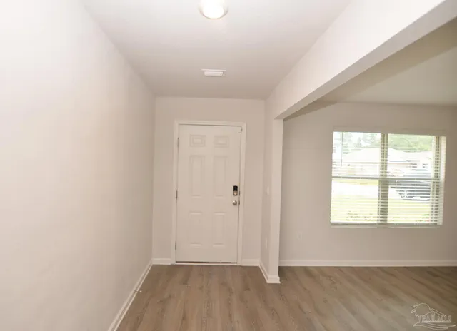 a kitchen with stainless steel appliances a stove top oven a sink a refrigerator white cabinets and wooden floor