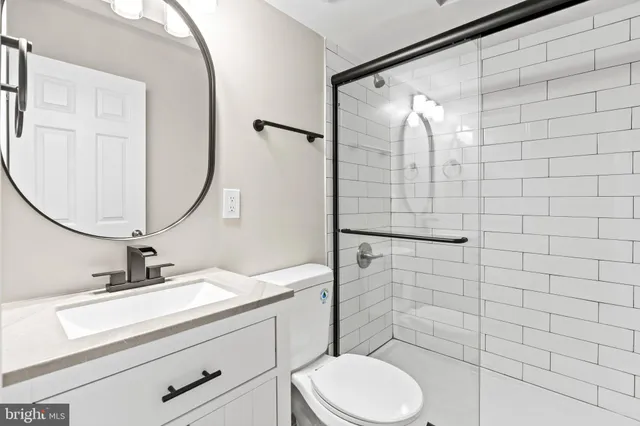 a bathroom with a sink mirror vanity and toilet