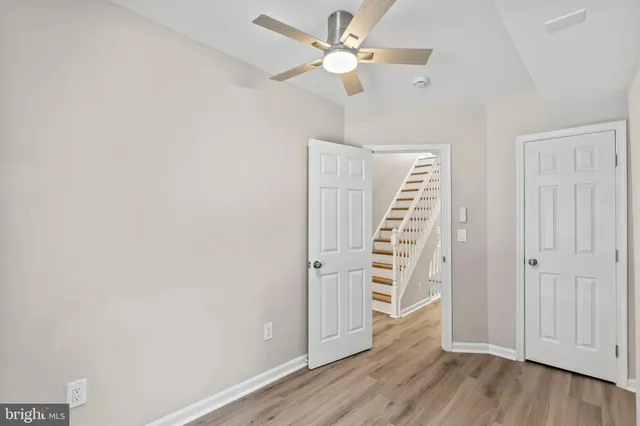 wooden view of an empty room with wooden floor and ceiling fan