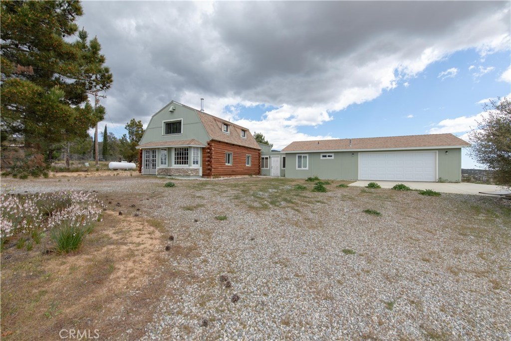 41790 Jay Dee Lane Anza, CA 92539 - Photo 13 of 22 a front view of a house with a dirt yard and a large tree