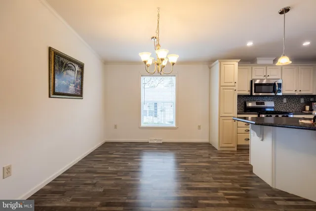 a view of a kitchen with a sink stove and wooden floor