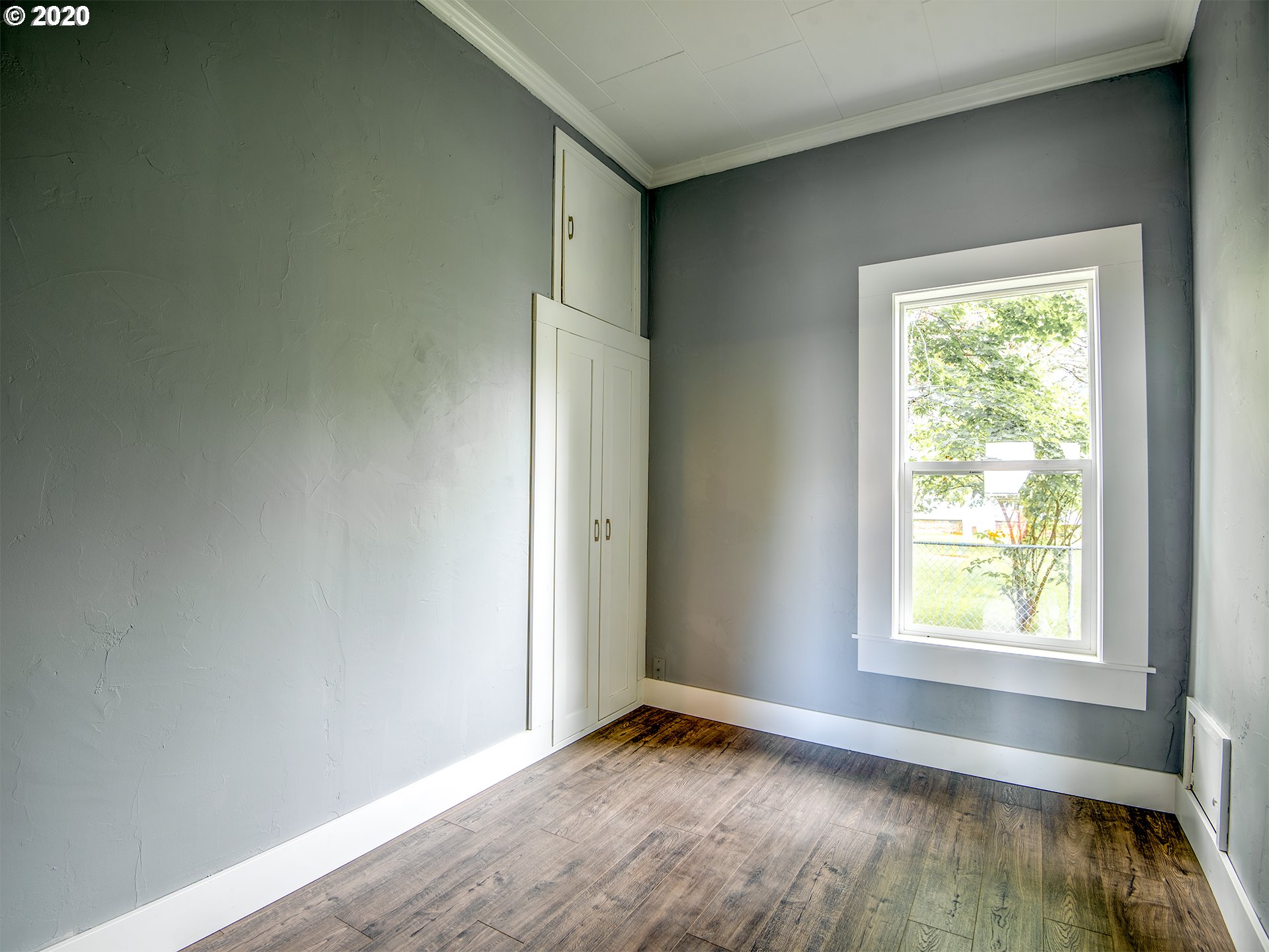1037 Walnut Street Baker City, OR 97814 - Photo 10 of 14 an empty room with wooden floor and windows