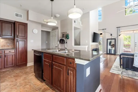 a kitchen with stainless steel appliances granite countertop a sink a stove and a refrigerator