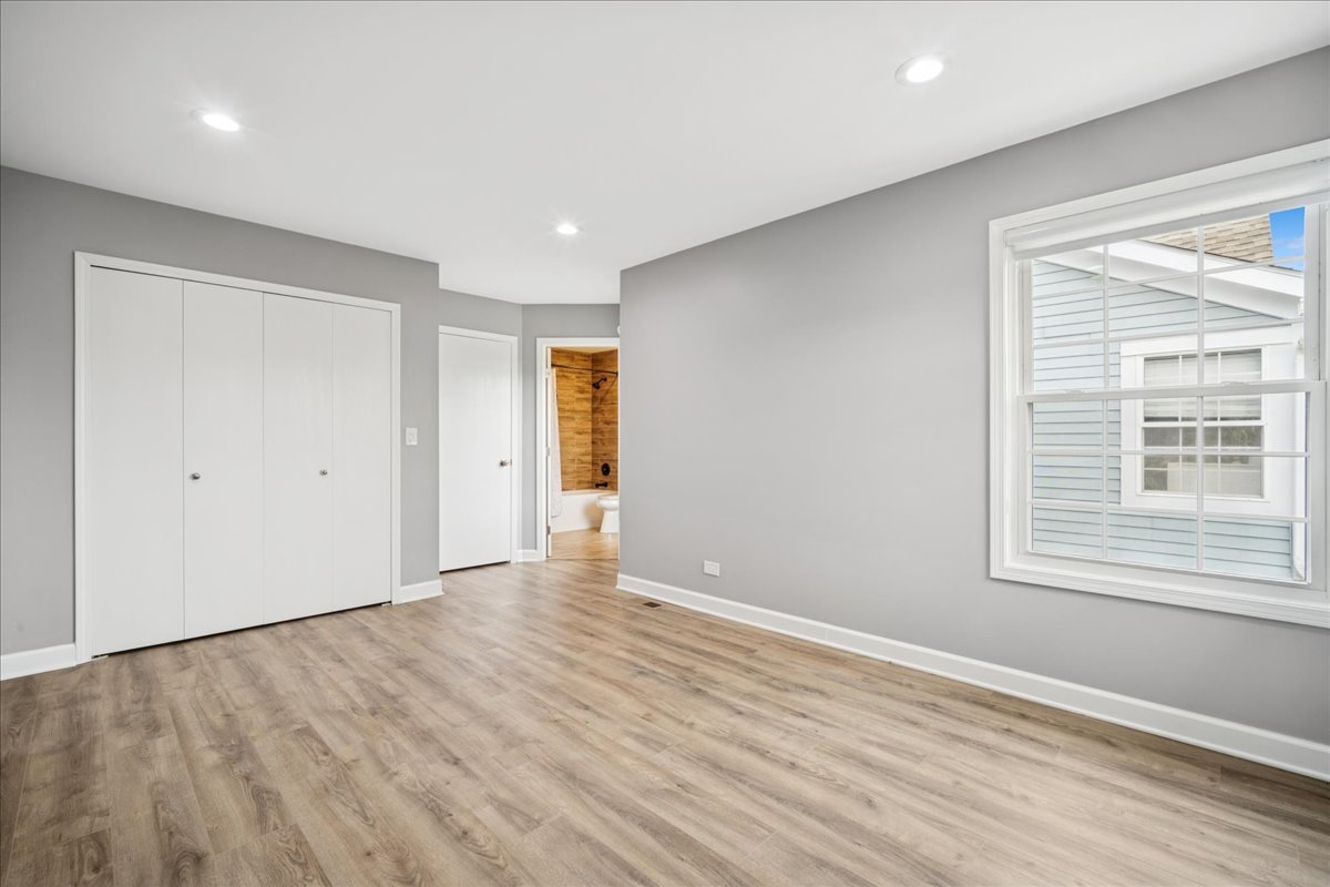 216 Winnsboro Court, Unit A Schaumburg, IL 60193 - Photo 16 of 20 a view of an empty room with wooden floor and a window