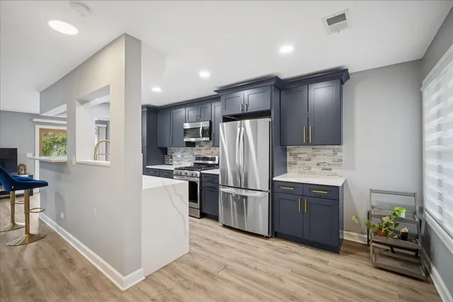a kitchen with a refrigerator and a stove top oven