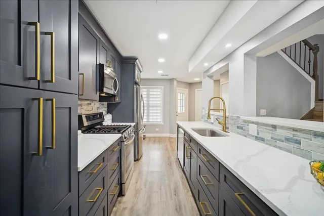 a kitchen with stainless steel appliances granite countertop a sink stove and refrigerator