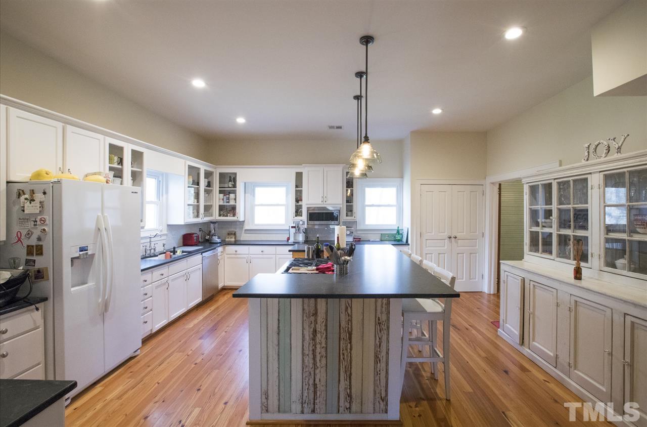 2730 Little River Church Road Hurdle Mills, NC 27541 - Photo 16 of 25 a kitchen with stainless steel appliances granite countertop a refrigerator a oven a sink dishwasher and white cabinets with wooden floor