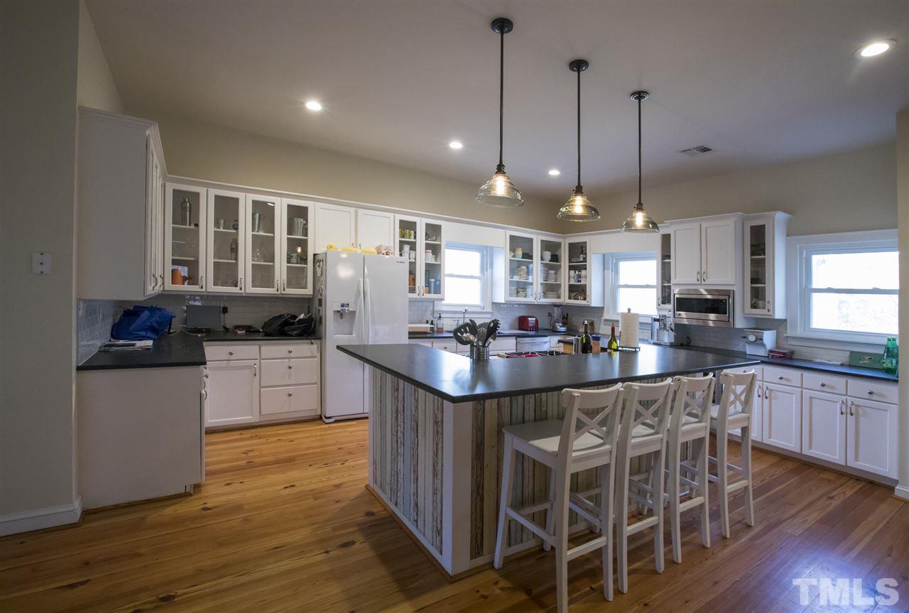2730 Little River Church Road Hurdle Mills, NC 27541 - Photo 18 of 25 a kitchen with stainless steel appliances granite countertop wooden floors and white cabinets